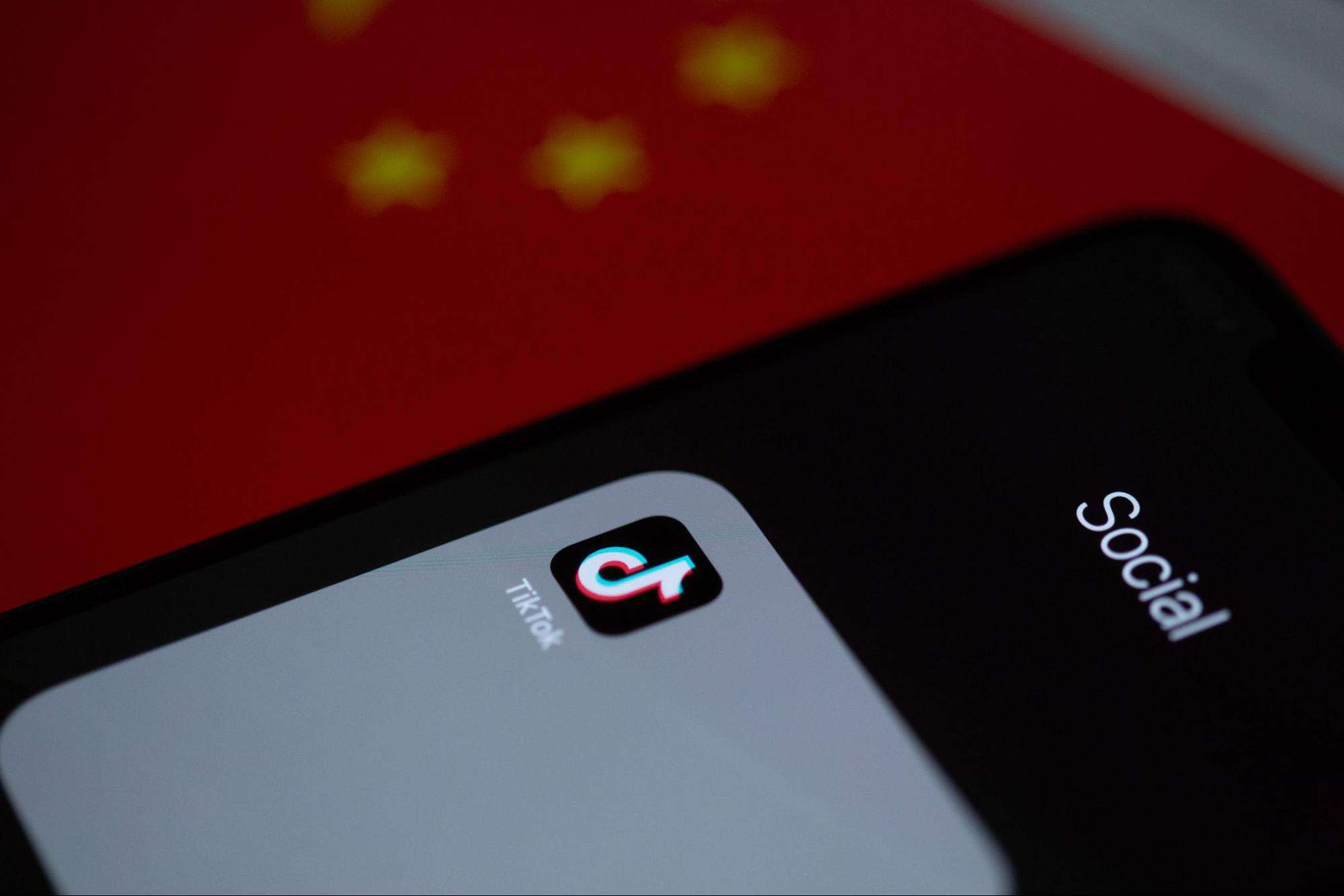 TikTok app on smartphone with Chinese flag background.